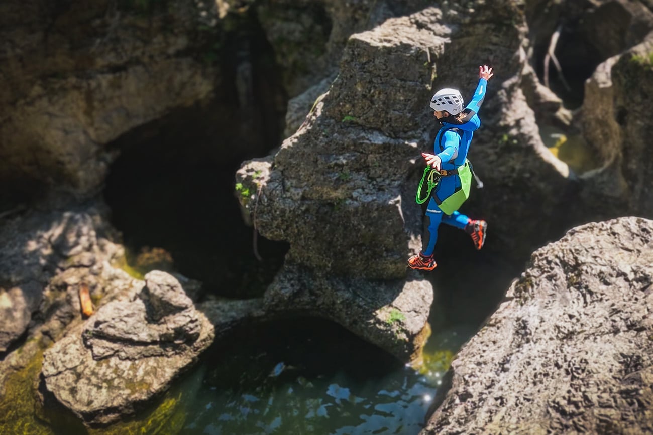 Beginner canyoning near Salzburg, Austria: a kid jumps into a natural pool in Almbachklamm (Wiestal/Hallein) during a guided small‑group canyoning tour.